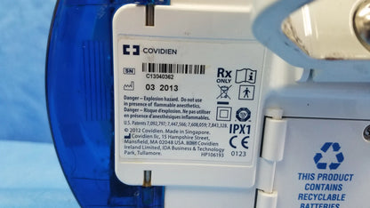 White plastic label with covidien logo and black text on the back of a nutrition feeding pump with barcode and serial number