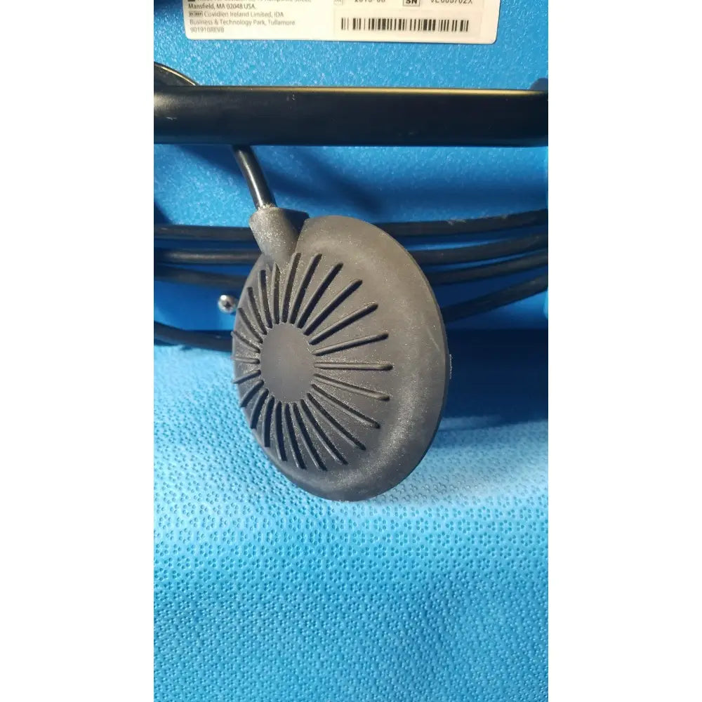 Gray circular speaker with radial slits and black cable of covidien se3690 smoke evacuator device