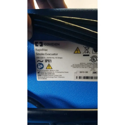 Blue plastic covidien se3690 smoke evacuator with ribbed texture and technical specifications label visible
