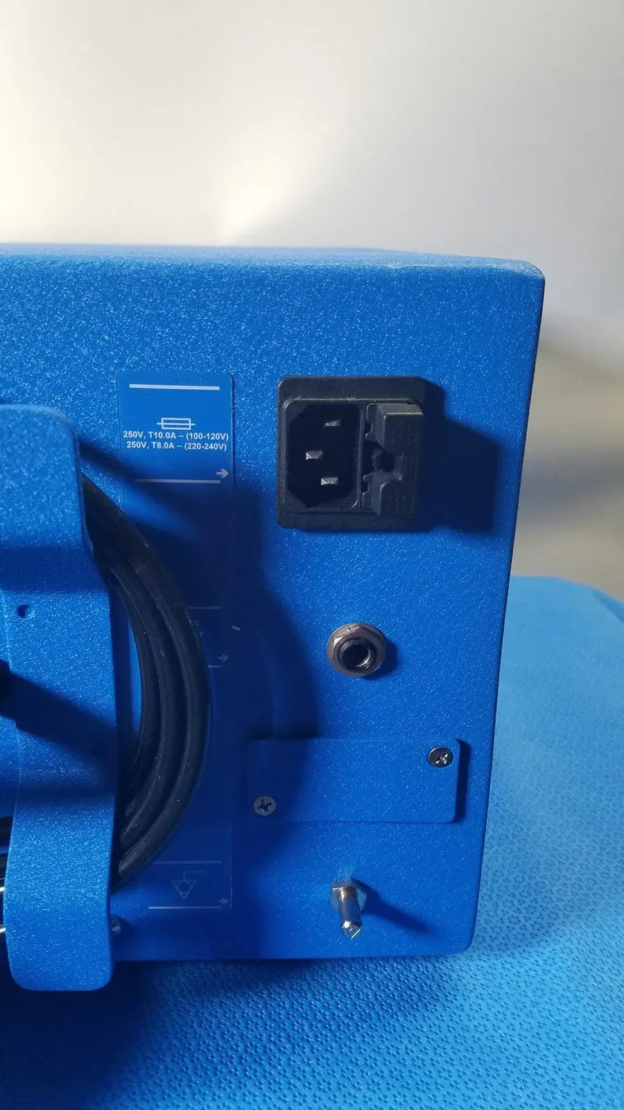 Blue textured power supply unit with black ac input plug and grounding screw on the back of covidien se3690 smoke evacuator