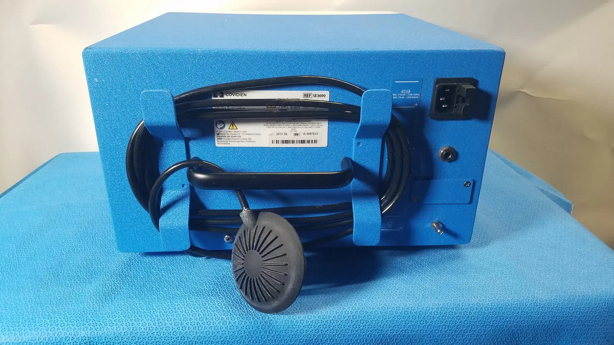 Blue rectangular covidien se3690 smoke evacuator with black coiled cable and gray circular fan attachment for smoke removal