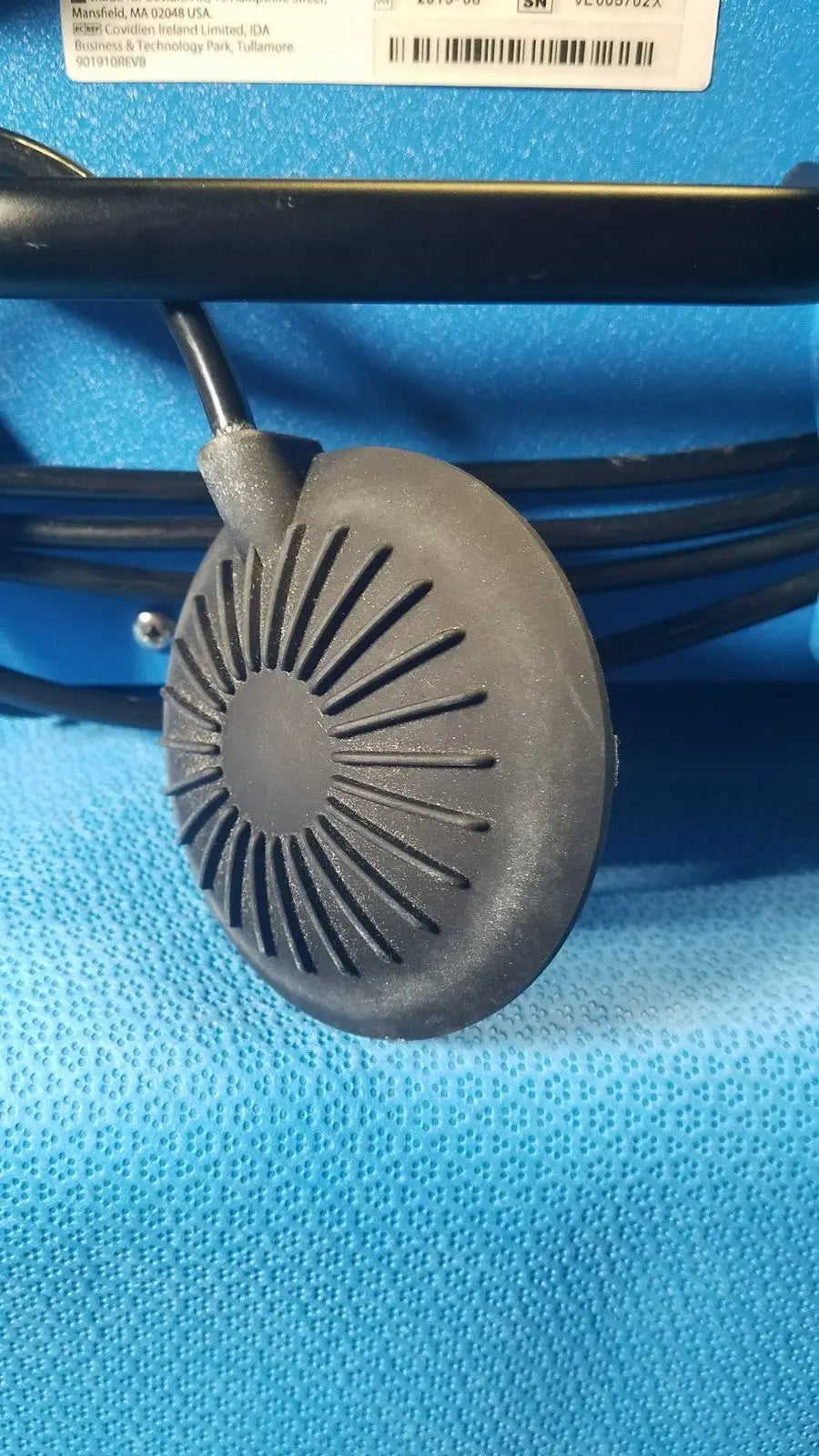 Gray circular speaker with radial slits and black cable of covidien se3690 smoke evacuator device