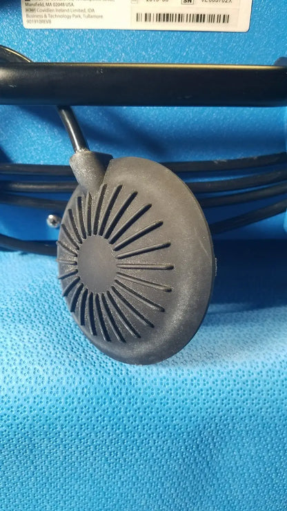 Gray circular speaker with radial slits and black cable of covidien se3690 smoke evacuator device