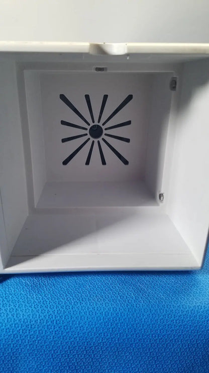 White plastic box with black radial vent pattern on interior of covidien se3690 smoke evacuator device