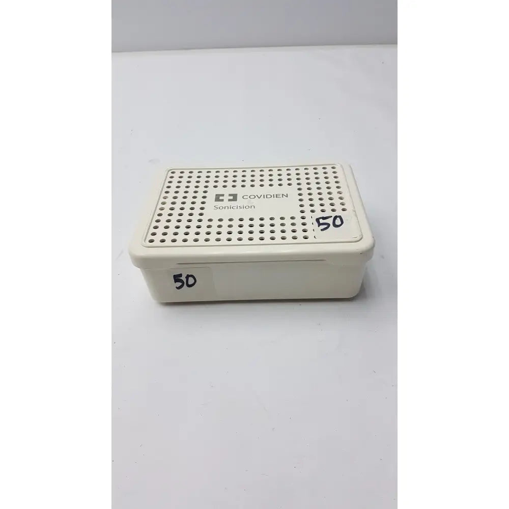 Cream-colored plastic covidien sonicision sterilization container tray with perforated lid for sonicision sterilization use