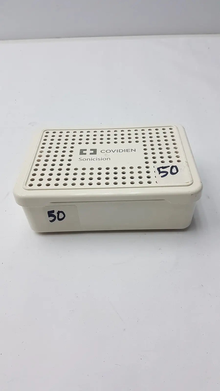 Cream-colored plastic covidien sonicision sterilization container tray with perforated lid for sonicision sterilization use