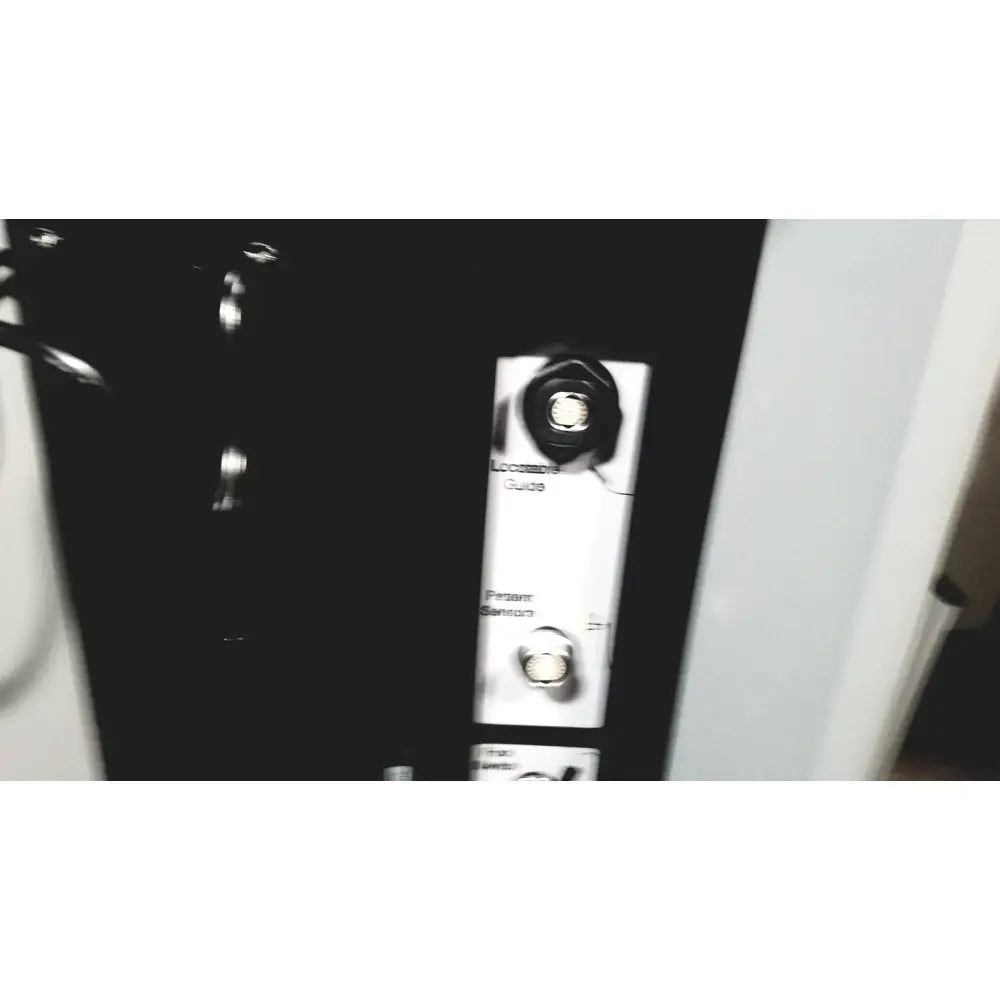 Black plastic panel with white labels and silver circular components on the back of covidien super dimension i logic in reach navigation system