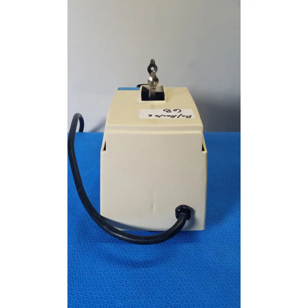 Beige plastic crescent dental wig-l-bug amalgamator with black cord and metallic key switch for dental use