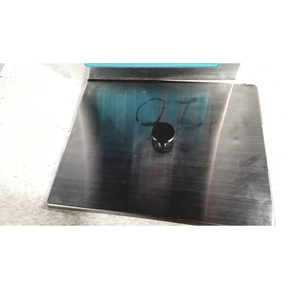 Black cylindrical magnet resting on brushed stainless steel surface of crest ultrasonic powersonic cleaner model p1100d