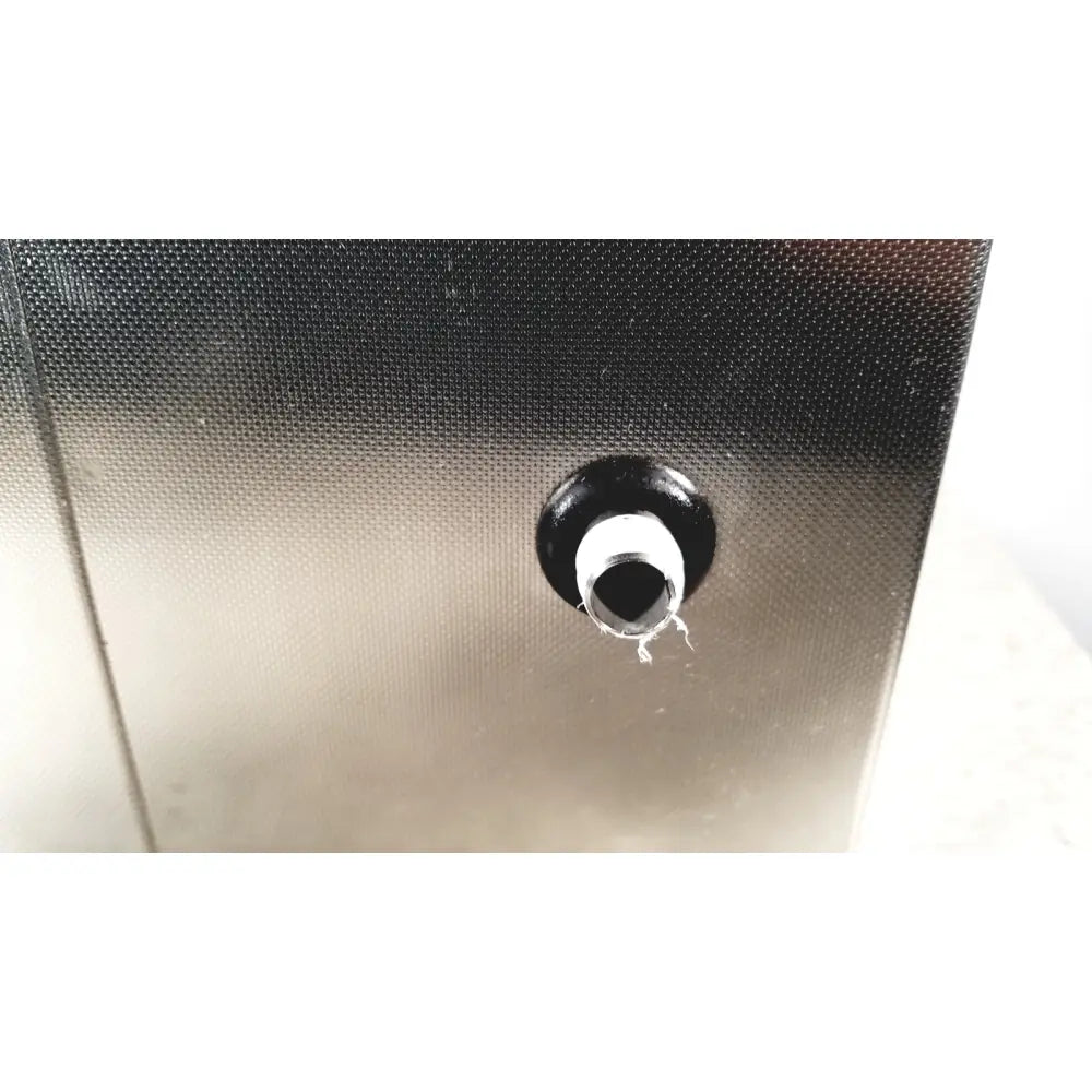 Black rubber grommet with white inner ring set into textured metallic surface of crest ultrasonic powersonic cleaner model p1100d
