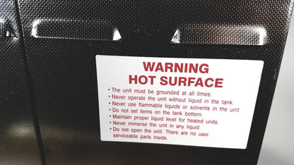 Black textured surface with white warning label and red text warning hot surface on crest ultrasonic powersonic cleaner model p1100d