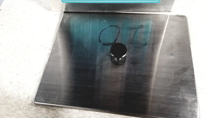 Black cylindrical magnet resting on brushed stainless steel surface of crest ultrasonic powersonic cleaner model p1100d