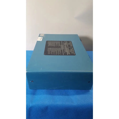Blue rectangular metal box with black label and white sticker on top of critikon dinamap 1846 sx vital signs monitor