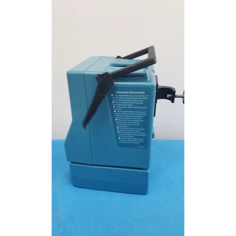 Blue plastic polaroid instant camera with black handle and clamps shown with critikon dinamap plus vital signs monitor 8726 rad not turning on