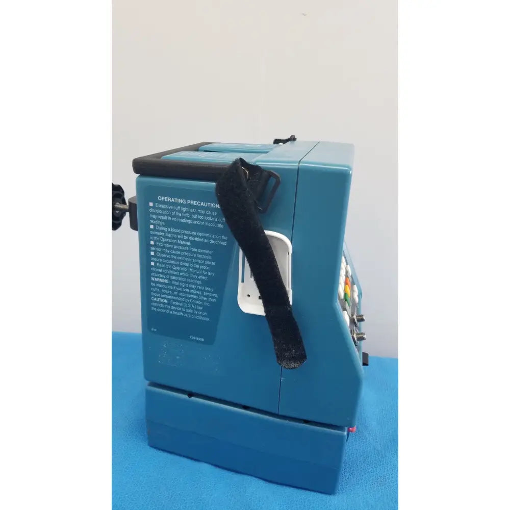 Blue medical-grade critikon dinamap plus vital signs monitor 8726 RAD with black velcro strap and colored buttons not turning on