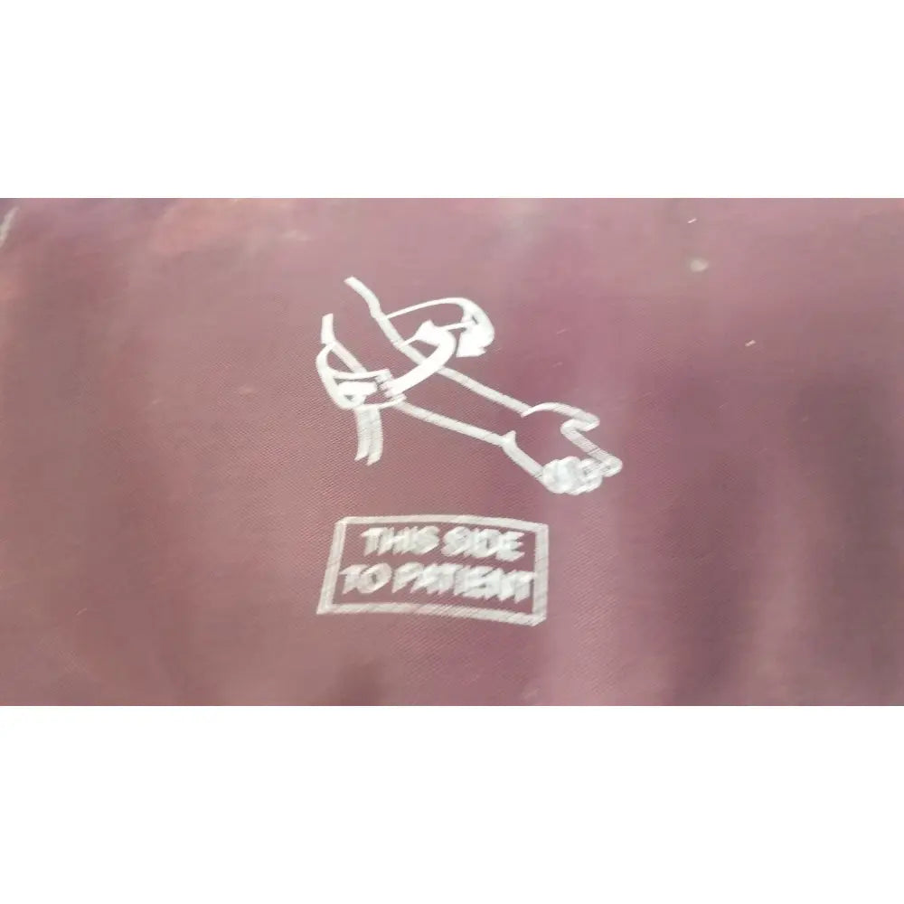 Maroon fabric pouch with white embroidered stylized figure and this side to patient text for large adult blood pressure cuff