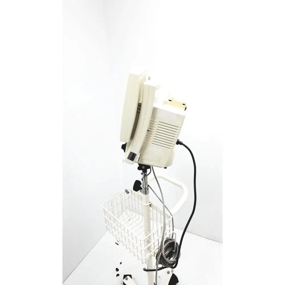 Beige csi criticare 8100 series poet plus vital signs patient monitor mounted on white adjustable stand with wire basket
