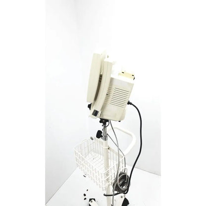 Beige csi criticare 8100 series poet plus vital signs patient monitor mounted on white adjustable stand with wire basket