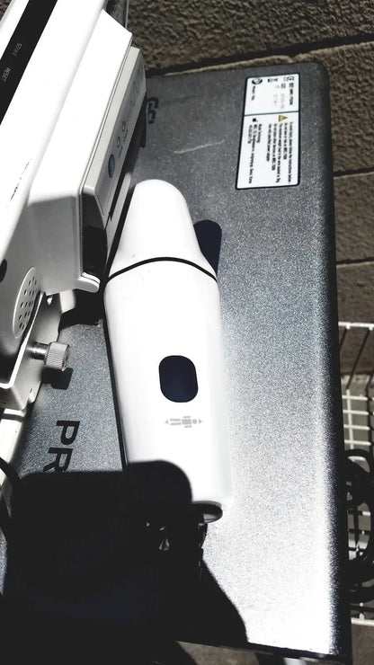 White handheld vacuum cleaner with sleek cylindrical design and black accents for bladder volume measurement system