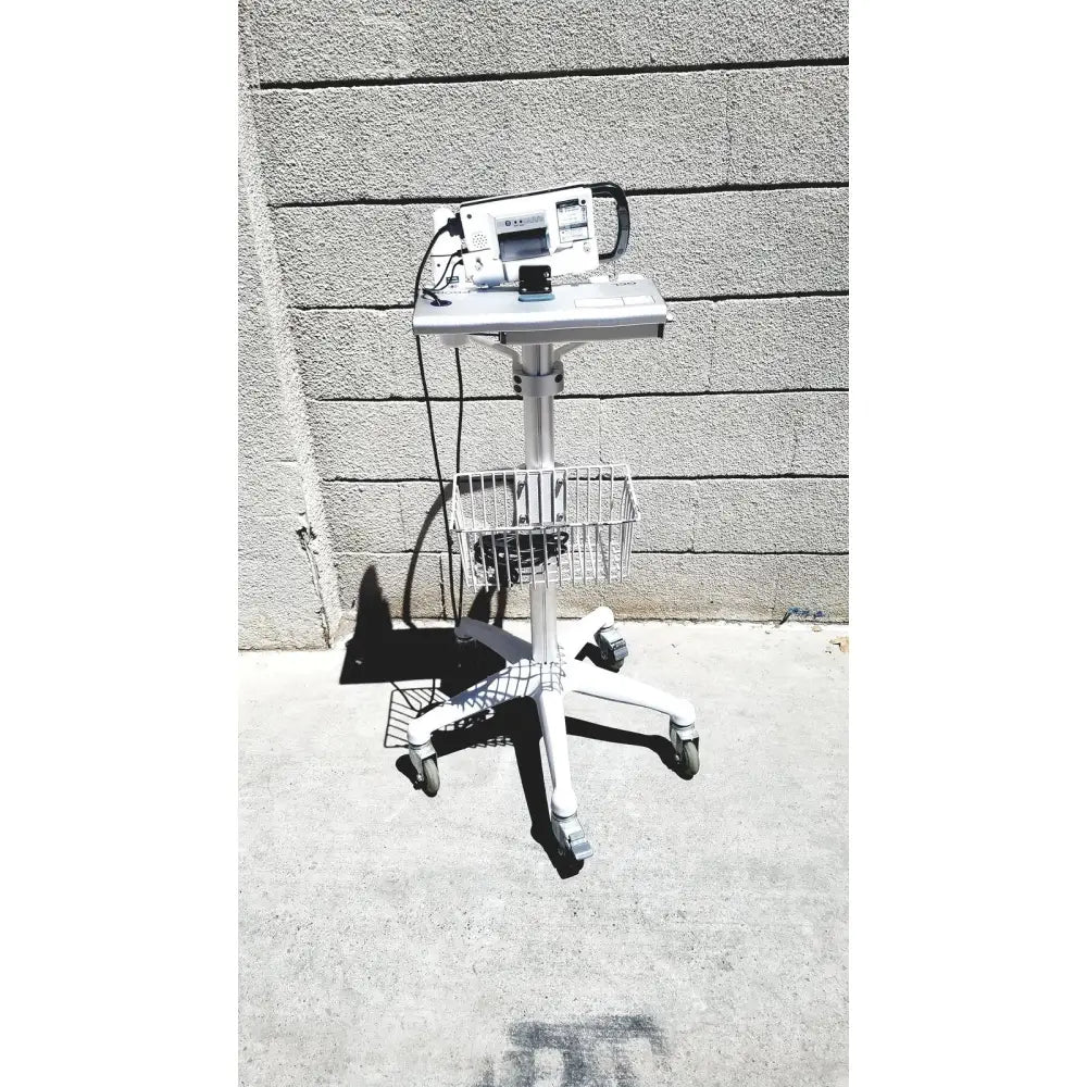 White medical cart with wheeled base and metal basket holding cubescan biocon-700 for bladder volume measurement