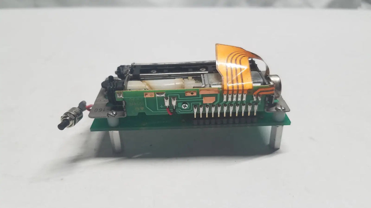 Green data synceng circuit board with orange flexible ribbon cable and metallic components featuring PIC16F628A chip
