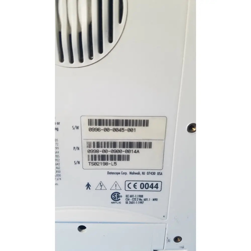 White plastic label with black barcode and datascope corp manufacturer on the back of an ekg patient monitor