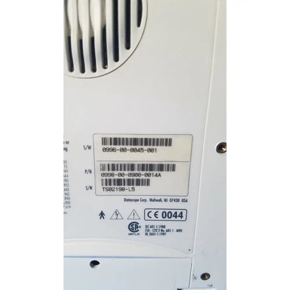 White plastic label with black barcode and datascope corp manufacturer on the back of an ekg patient monitor