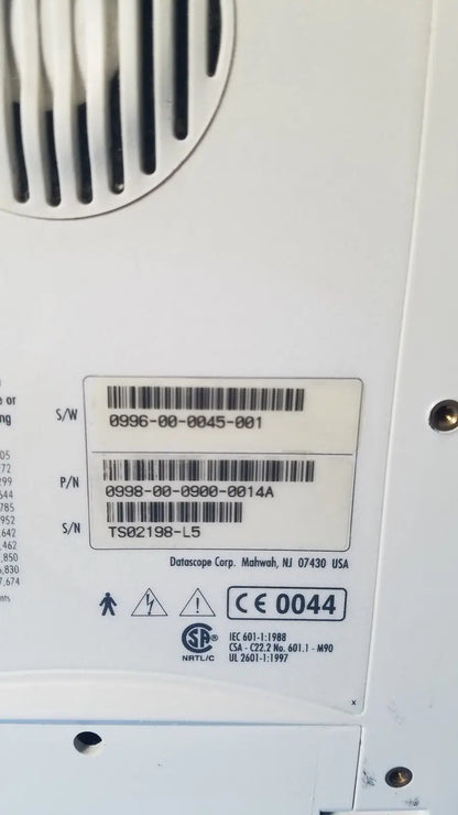 White plastic label with black barcode and datascope corp manufacturer on the back of an ekg patient monitor