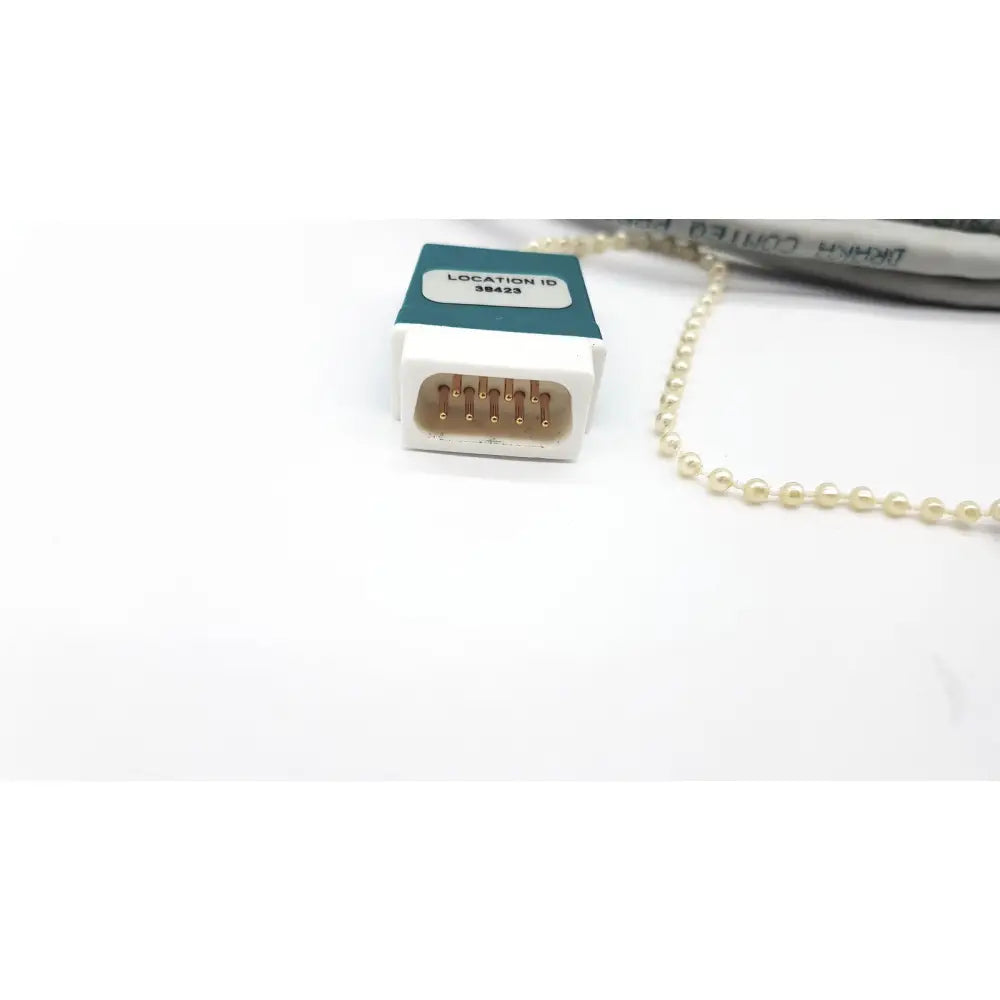 White plastic Datex Ohmeda network cable connector with gold pins and teal label location id 38423 10ft length