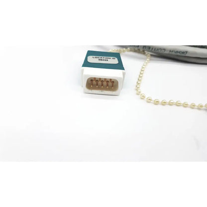 White plastic Datex Ohmeda network cable connector with gold pins and teal label location id 38423 10ft length