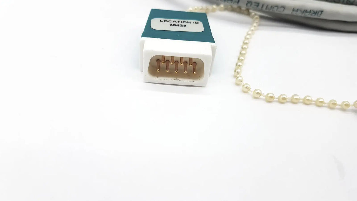 White plastic Datex Ohmeda network cable connector with gold pins and teal label location id 38423 10ft length