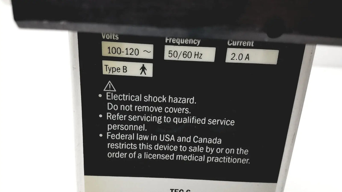 Black electrical specification label on the back of datex ohmeda tec 6 desflurane anesthesia vaporizer with voltage and safety details