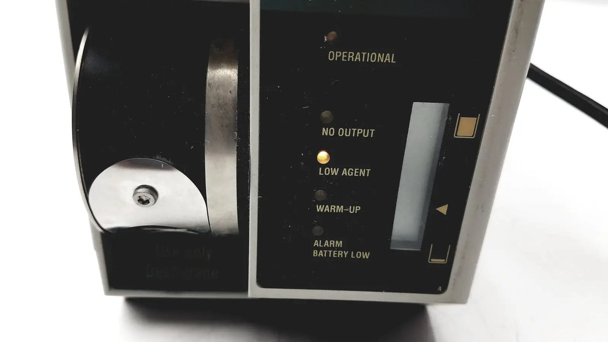 Black and silver datex ohmeda tec 6 desflurane anesthesia vaporizer with illuminated status indicators for precise anesthesia delivery