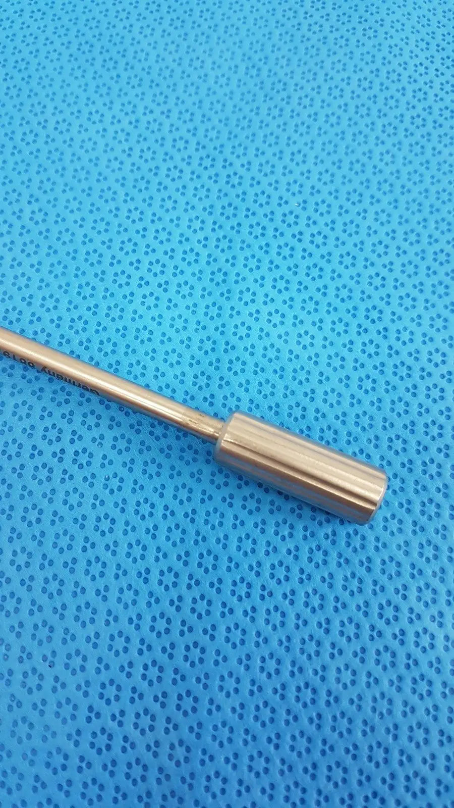 Davis + Geck surgical instrument model 8381-01 features a sleek metallic rod with a polished brass finish and rounded end cap