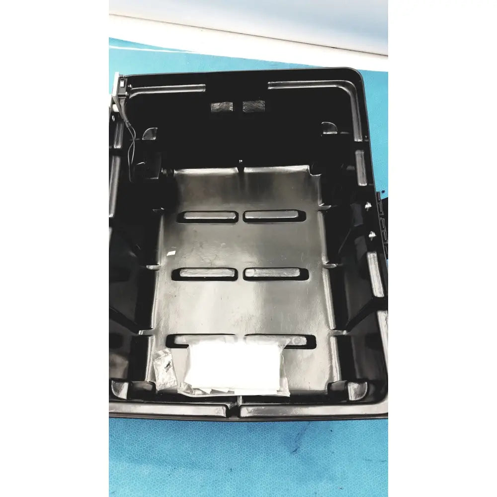 Black plastic tray with metallic silver insert and rectangular cutouts for defibrillator storage cabinet wall mount