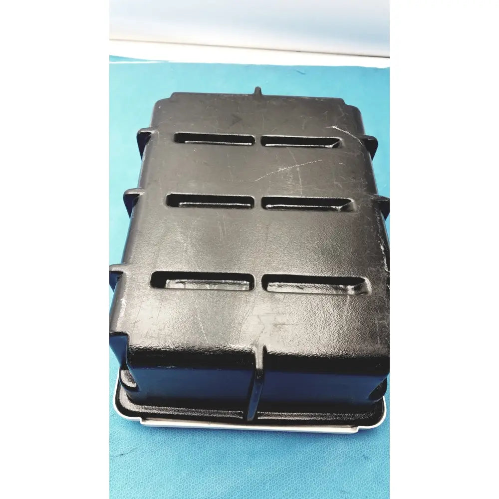 Black plastic defibrillator storage cabinet wall mount with three horizontal slots on each side for secure storage