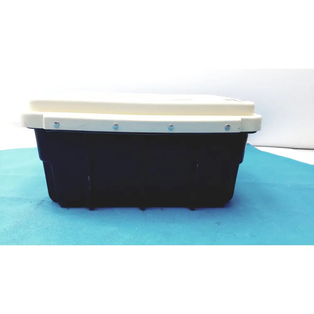 Black plastic defibrillator storage cabinet wall mount with cream-colored lid secured by four silver screws