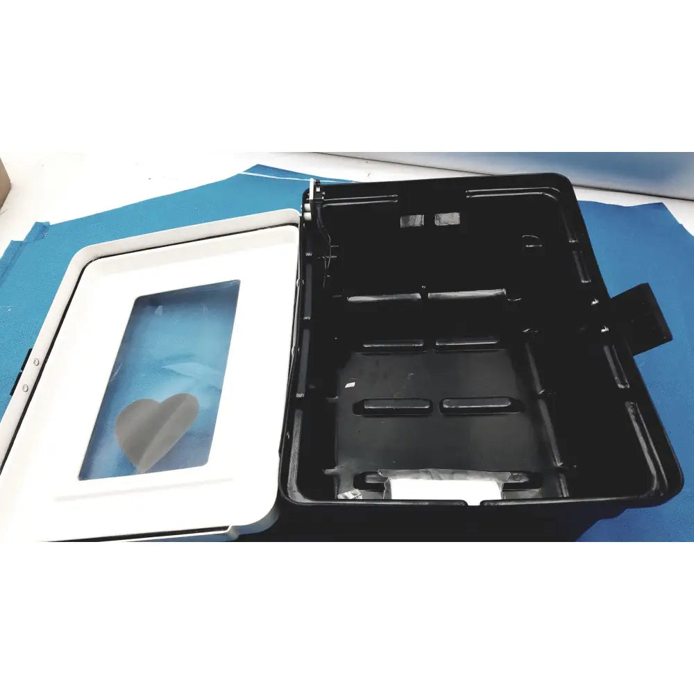 Black plastic defibrillator storage cabinet with white lid and heart-shaped window for cabinet wall mount use