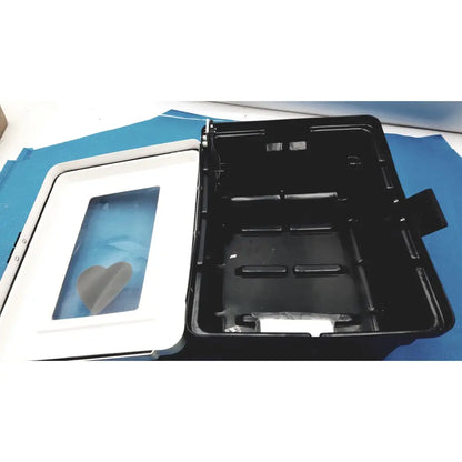 Black plastic defibrillator storage cabinet with white lid and heart-shaped window for cabinet wall mount use