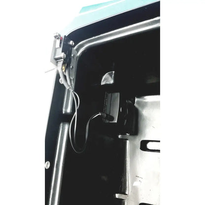 Black rectangular camera mounted inside vehicle interior with wiring and metal brackets on defibrillator storage cabinet wall mount