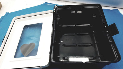 Black plastic defibrillator storage cabinet with white lid and heart-shaped window for cabinet wall mount use
