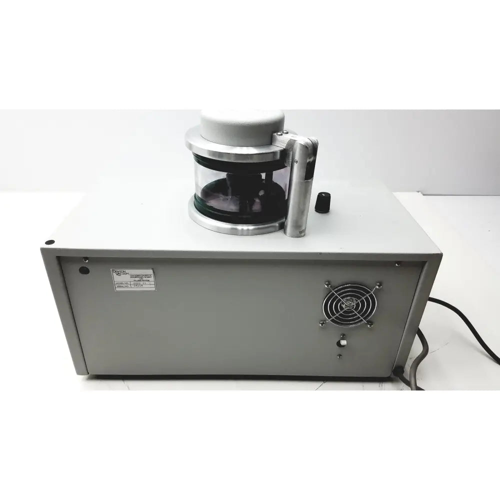 Gray metal laboratory centrifuge with transparent rotor chamber and silver handle in denton vacuum desk evaporator system