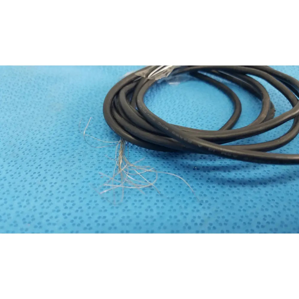 Coiled black electrical cable with exposed frayed wires for dentsply cavitron foot control serial no f062373