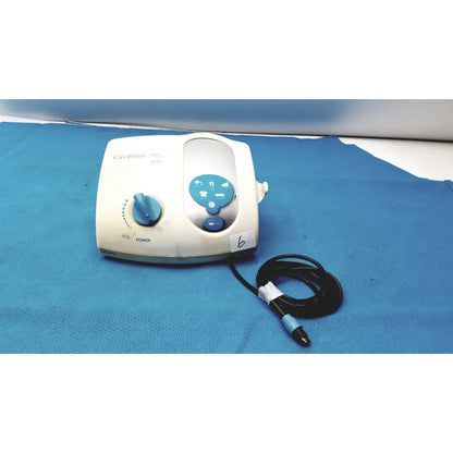 White and blue dentsply cavitron plus ultrasonic scaling unit type gen-131 with coiled black cable visible from the back side