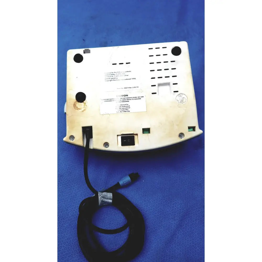 White plastic dentsply cavitron plus ultrasonic scaling unit with black power cord and connector shown from the back side