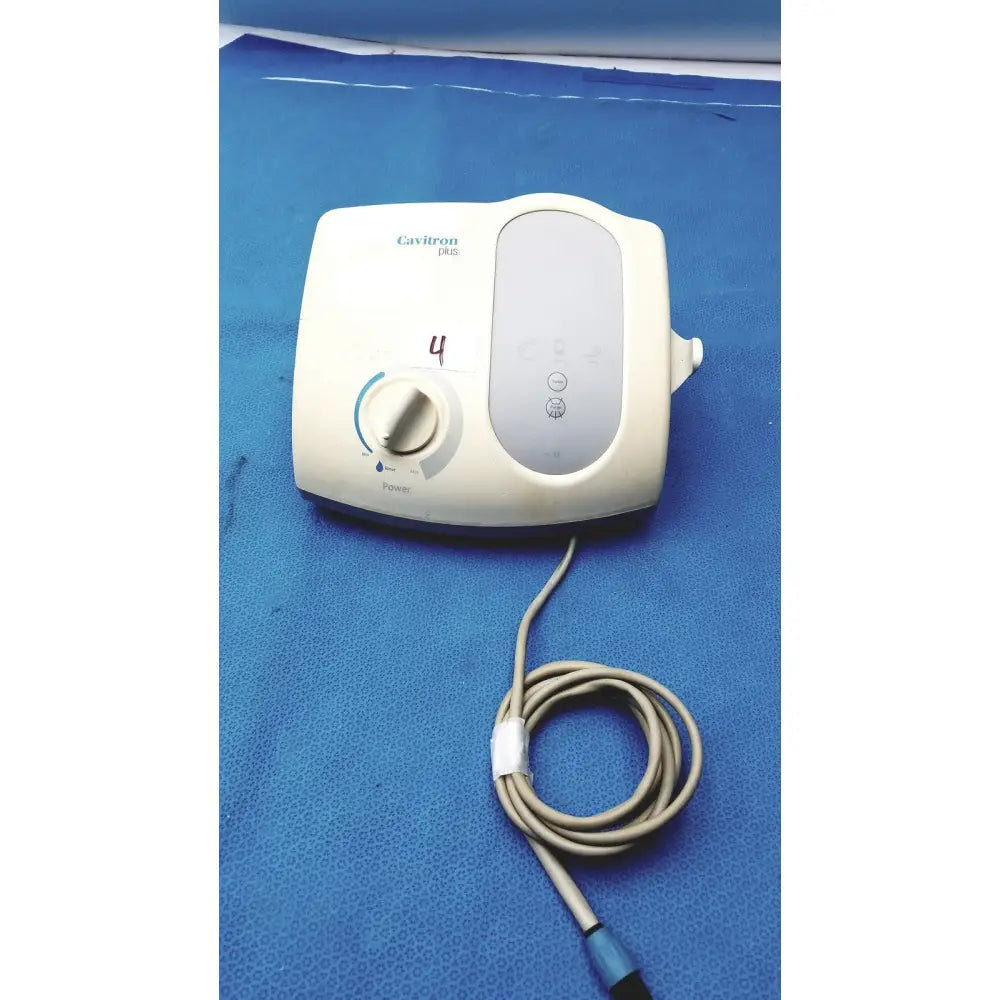 Cream-colored dentsply cavitron plus ultrasonic scaling unit type GEN-136 with coiled beige cable and blue connector