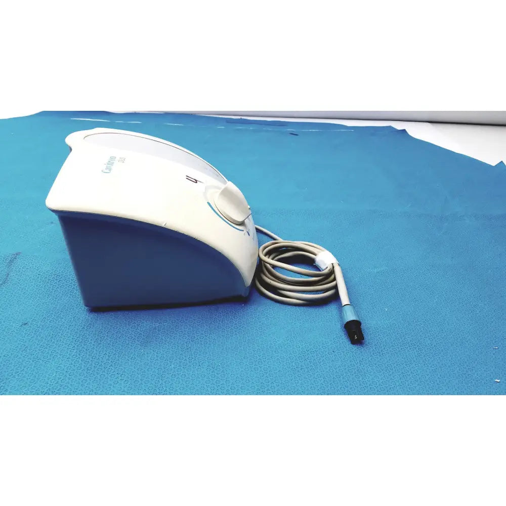 White and blue dentsply cavitron plus ultrasonic scaling unit base with coiled gray charging cord for plus ultrasonic use