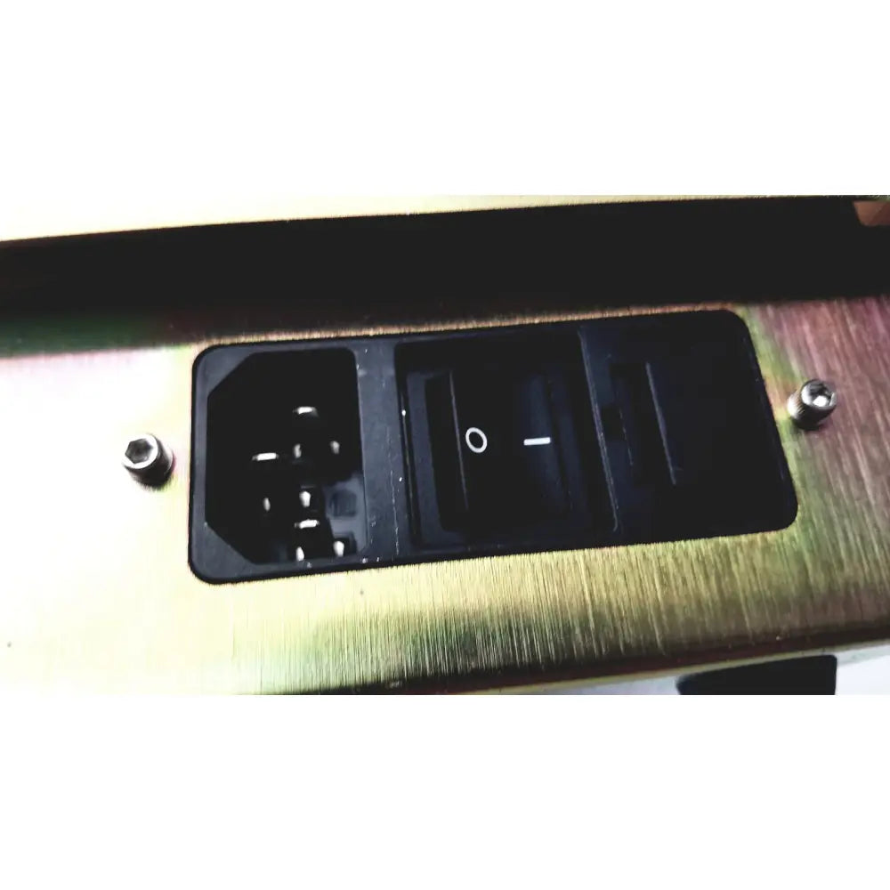 Black power input and toggle switch panel set into brushed gold metal surface on dickinson facs loader electronics module