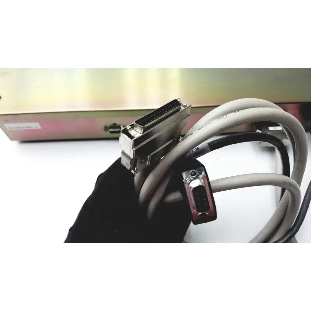 Gray and black industrial cable with metallic d-sub and db-9 serial port on the back of dickinson facs loader electronics interface module