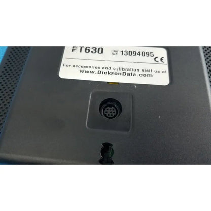 Black plastic dickson data logger model ft630 with white label and circular connector port on the back side